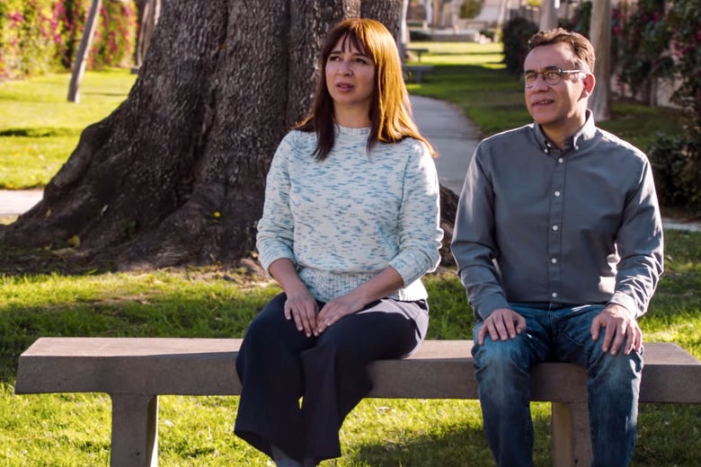 Maya Rudolph and Fred Armisen sit on a bench in a still from Forever.